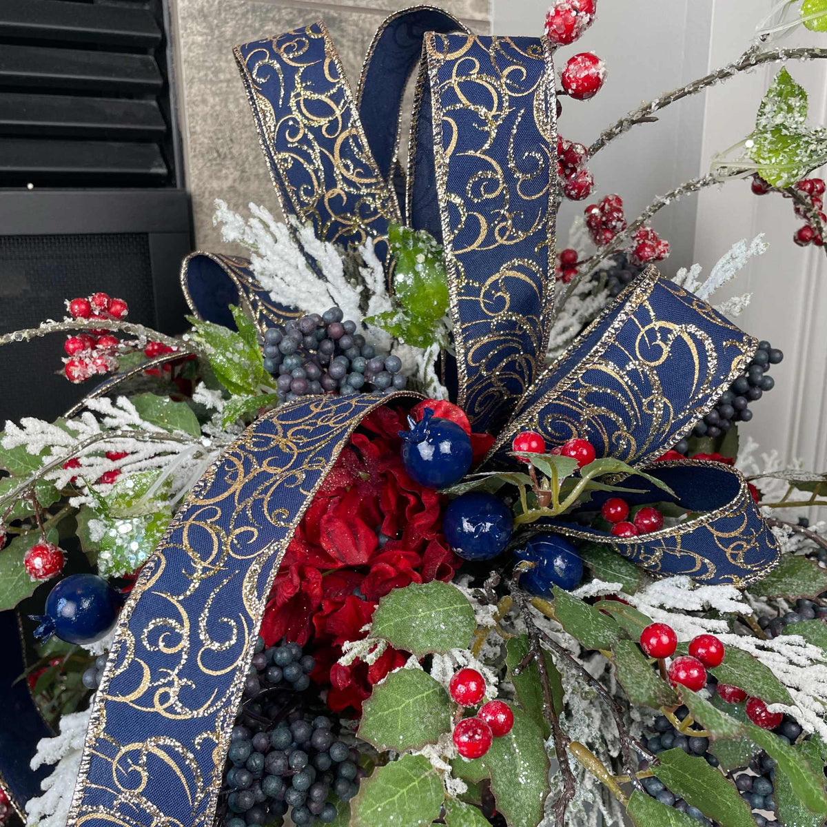 Christmas Floral Centerpiece with Iced Berries & Navy Blue Bow in Cast Iron Vase