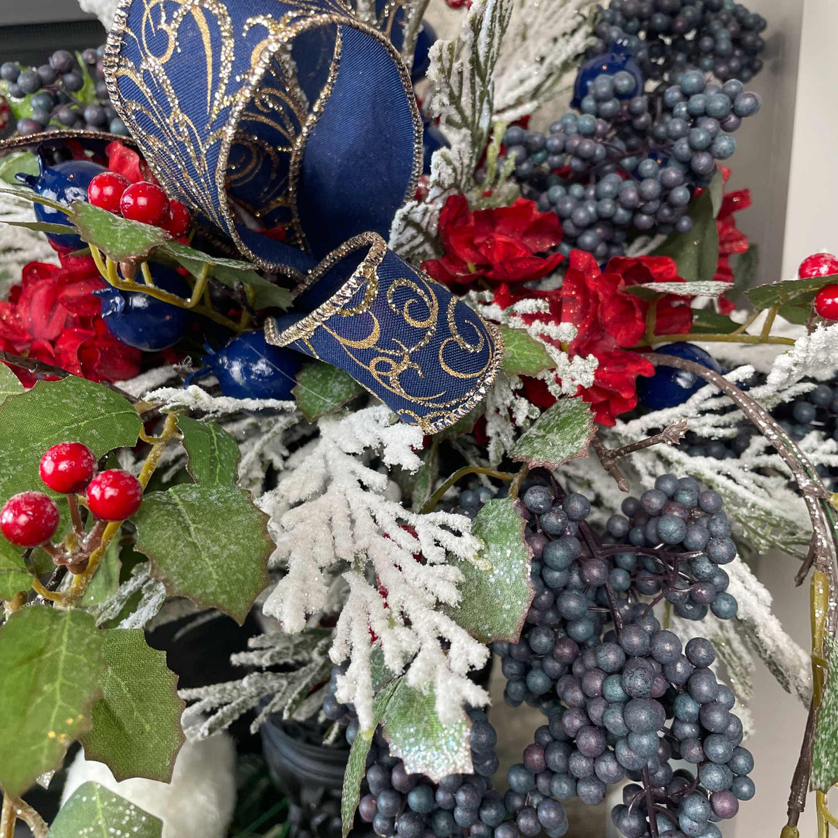 Christmas Floral Centerpiece with Iced Berries & Navy Blue Bow in Cast Iron Vase