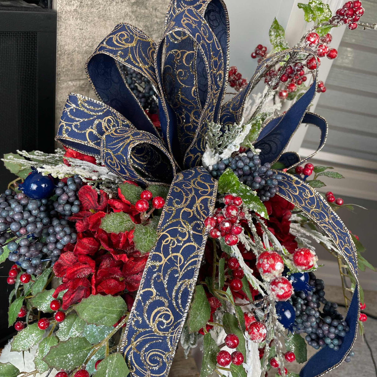 Christmas Floral Centerpiece with Iced Berries & Navy Blue Bow in Cast Iron Vase